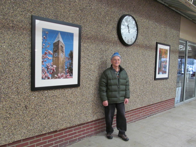 JIm stands near a large framed 