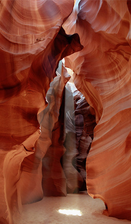 A shaft of sunlight illuminates water carved sandstone in upper Antelope Canyon, AZ